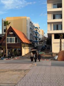 a group of people walking down a city street at Mehdia plage in Kenitra