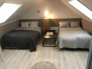 a attic bedroom with two beds and a table at Private room on quiet street in Bodø