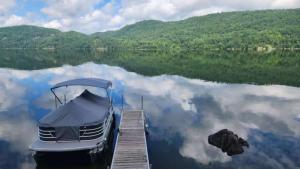 a boat parked at a dock on a lake at Chalet l'Apero in Val-des-Bois