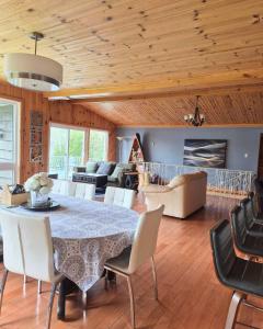 a dining room and living room with a table and chairs at Chalet l'Apero in Val-des-Bois