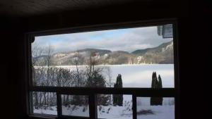 a window with a view of a snow covered lake at Chalet l'Apero in Val-des-Bois
