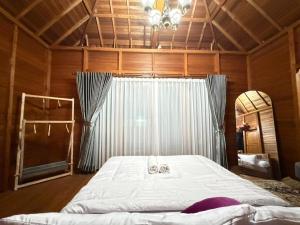 a large bed in a room with a large window at Pondok Nisya in Sawan