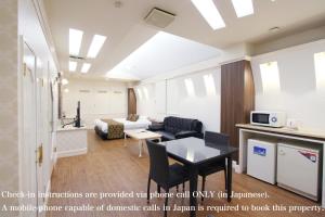 a living room with a couch and a table at パティオ山梨 - 大人専用 - in Fuefuki