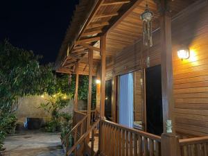 a wooden porch of a house at night at Pondok Nisya in Sawan