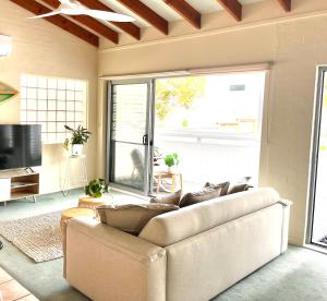 a living room with a couch and a large window at Blueys Motel in Blueys Beach
