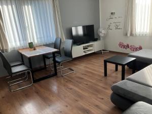 a living room with a television and a table and chairs at Wienerwaldblick in Mauerbach