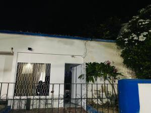 a white house with a gate and a plant at Casa Edi Hostal Santa Marta in Santa Marta