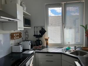 a kitchen with white cabinets and a black counter top at Wienerwaldblick in Mauerbach +19 photos