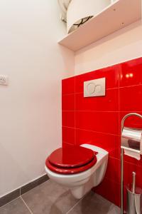 a red bathroom with a toilet with a red wall at Le Logis de Montmartre in Paris +20 photos