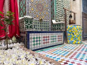 a room with colorful tiles and flowers on the floor at Hostel Dar Caftan in Fez