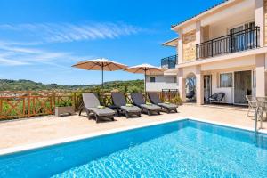 a villa with a swimming pool and patio furniture at Villa Naisy in Tsilivi