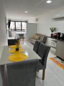 a kitchen and living room with a table and chairs at Loft moderno e completo a 200m do Consulado Americano in Porto Alegre