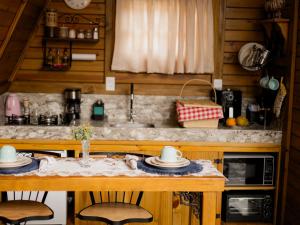 a kitchen with a table with two chairs and a sink at Refúgio Suiço em Vargem Alta in Vargem Alta