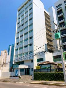a tall white building in front of a city at Ponta Negra Flat 305 in Natal
