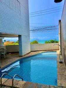 a swimming pool in front of a building at Ponta Negra Flat 305 in Natal