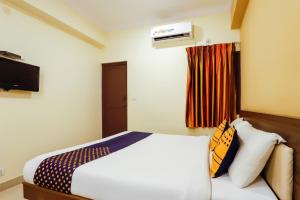 a hotel room with a bed and a television at SPOT ON Central Inn in Chennai