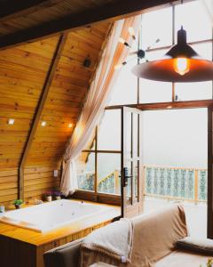 a large bathroom with a tub and a large window at Refúgio Suiço em Vargem Alta in Vargem Alta