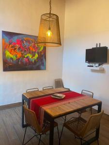 a dining room table with chairs and a painting on the wall at Villa Narcisa in Purmamarca