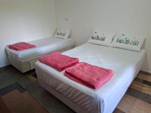 two beds in a room with red towels on them at Chácara Solar de Jarinu in Jarinu