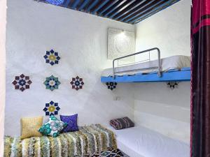 a room with two bunk beds and a couch at Hostel Dar Caftan in Fez