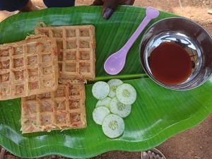 a green plate with waffles and a bowl of syrup at The Brookshore in Kodaikānāl