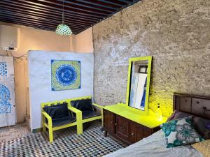 a bedroom with a yellow dressing table and a mirror at Hostel Dar Caftan in Fez