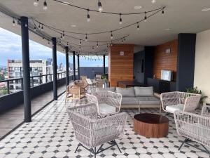 a patio with chairs and a couch on a balcony at Guadalajara American visa - 2 bedrooms in Milpillas