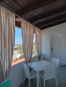a table and chairs in a room with a view of the ocean at CASA Pitosforo CASA Ulivo in Forio d'Ischia