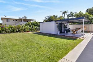 a garden with a patio and grass at Boutique Bribie Stay in Bellara