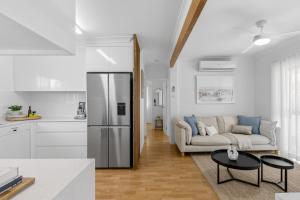 a kitchen and living room with a refrigerator and a couch at Boutique Bribie Stay in Bellara
