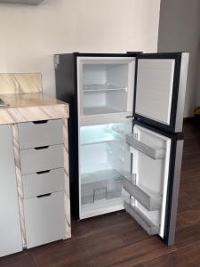 an empty refrigerator with its door open in a kitchen at Demi Apartment in Zaachila