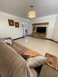 a living room with a couch and a flat screen tv at Sobrado Savana in Foz do Iguaçu