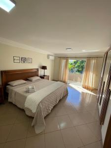 a bedroom with a large bed and a large window at Sobrado Savana in Foz do Iguaçu