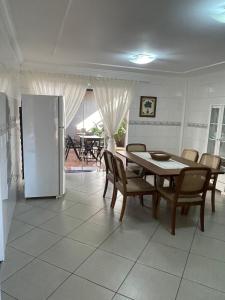 a dining room with a table and a refrigerator at Sobrado Savana in Foz do Iguaçu