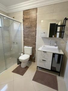 a bathroom with a toilet and a sink and a shower at Sobrado Savana in Foz do Iguaçu +14 photos