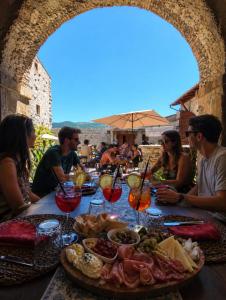 a group of people sitting around a table with food at LA MORA Exclusive in Moricone