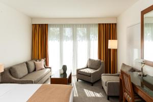 a hotel room with a bed and a couch and chair at Yarra Valley Lodge in Wonga Park