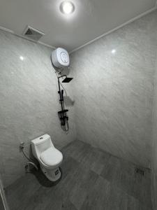 a bathroom with a toilet and a light on the wall at Penginapan Angsoka 1 in Singaraja