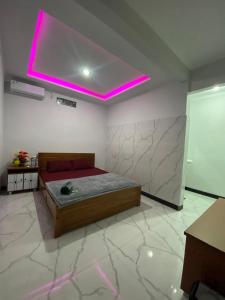 a bedroom with a bed with a pink light on the ceiling at Penginapan Angsoka 1 in Singaraja