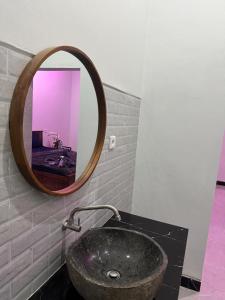 a bathroom with a stone sink and a mirror at Penginapan Angsoka 1 in Singaraja