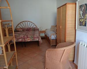 a room with a bed and a chair and a ladder at CASA Pitosforo CASA Ulivo in Forio d'Ischia