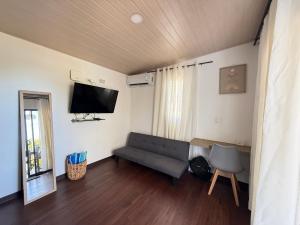 a living room with a couch and a flat screen tv at Avellanas Tiny Villa 1BR Private Self check in in Santa Cruz +5 photos