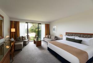 a bedroom with a large bed and a living room at Yarra Valley Lodge in Wonga Park