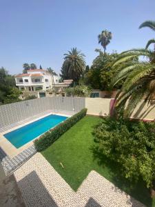 a backyard with a swimming pool and a garden at Villa Sais avec piscine in Meknès