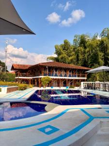 a resort with a swimming pool and a building at La orquídea campestre in Montenegro