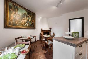uma cozinha com uma mesa e um quadro na parede em B&B Glicini em Roma
