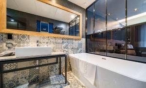 a bathroom with a large tub and a sink at Anseong Nomad Hotel in Anseong