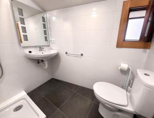 a white bathroom with a toilet and a sink at Casa Rural San Gregorio in Alcalá del Júcar +20 photos