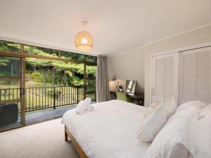 a bedroom with a white bed and a large window at Moana View in Paihia