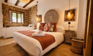a bedroom with a large bed and a bathroom at Al Zahra Suites in Zahara de la Sierra +30 photos